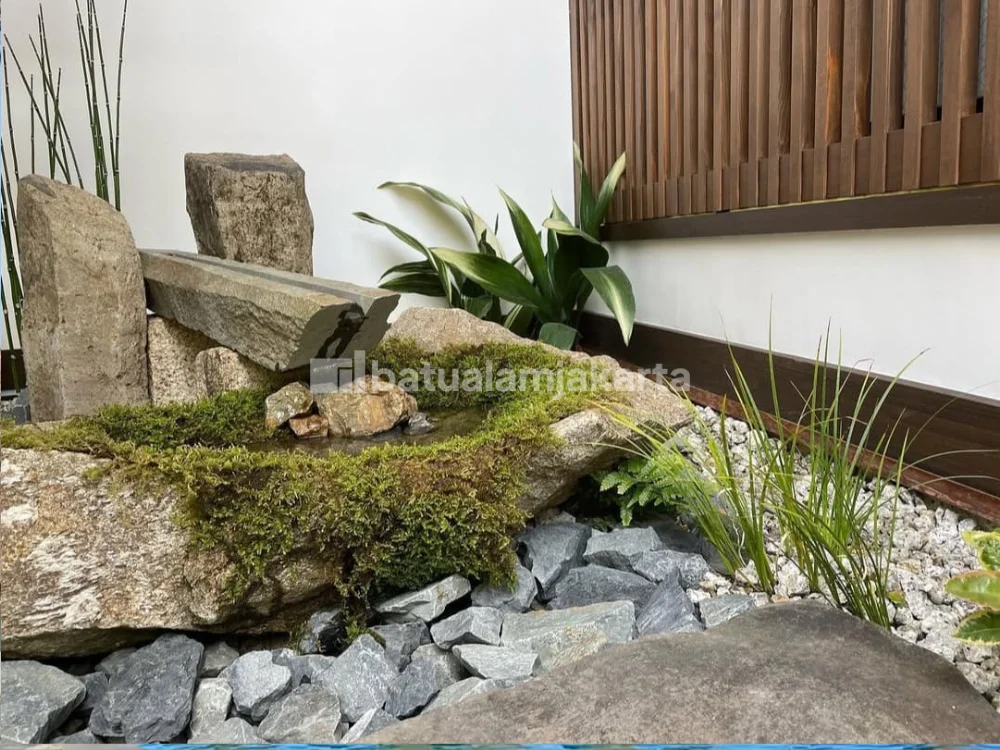 Batu megalitik alami dipadukan dengan koral dan tanaman pada taman Jepang