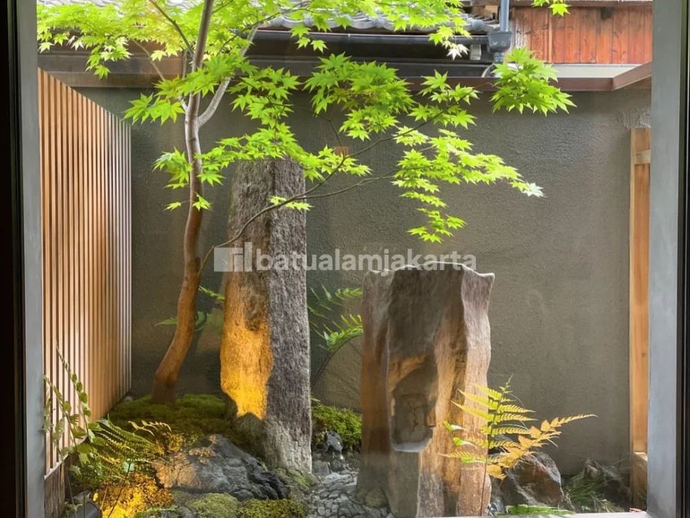 Batu megalitik artistik dengan pencahayaan landscape pada taman premium