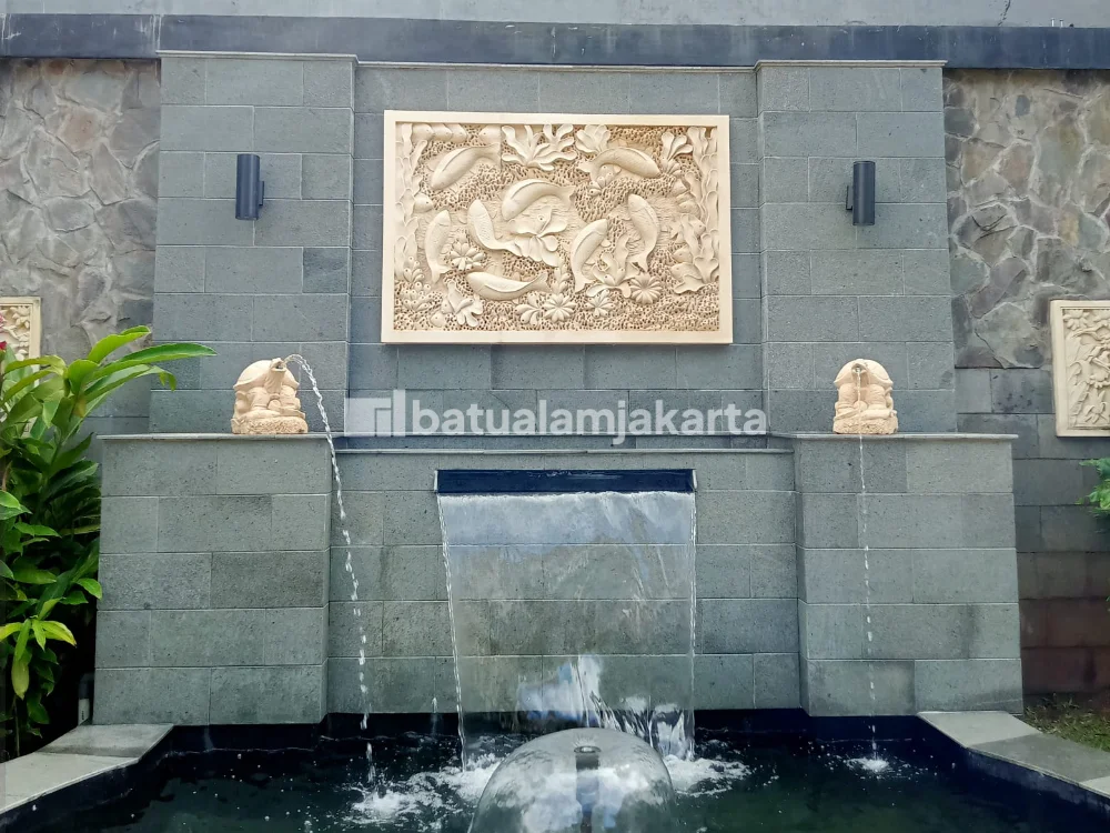dinding kolam ikan batu alam andesit dengan relief ukiran motif ikan